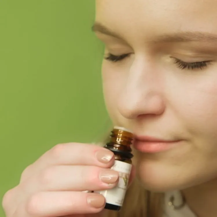 Relaxte vrouw ruikt aan Rozemarijn olie