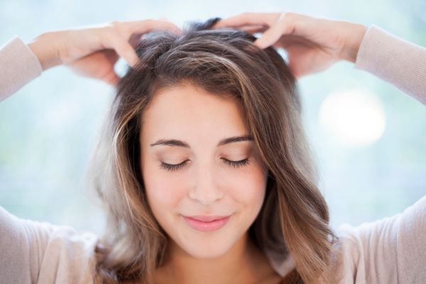 Blij en opgelucht vrouw die hoofdhuid en haar verzorging heeft gedaan met etherische olie