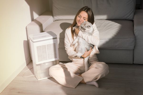 Vrouw met kat in kamer met goede luchtkwaliteit in huis