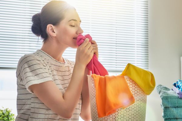 Vrouw ruikt aan kleren die lekker ruiken door wasparfum