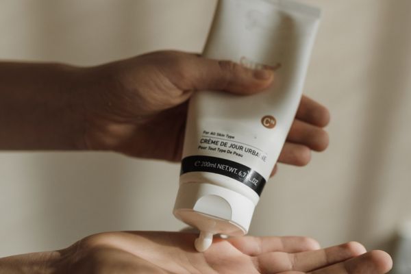 Een cosmetica creme op de huid in hand smeren