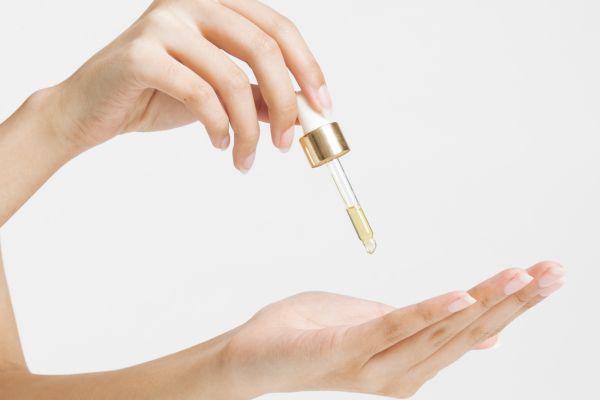 Skincare olie druppelen op hand voor gebruik