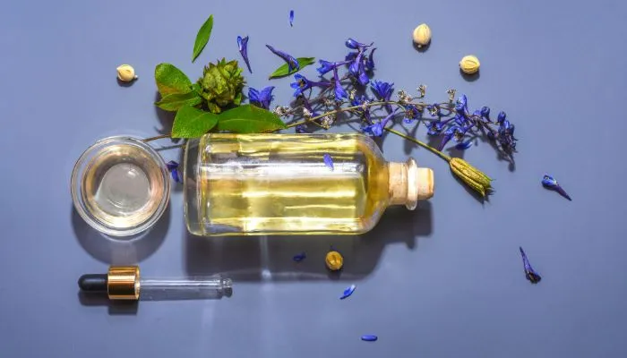 Flesje-oregano-met-druppelaar-bloemen-en-glas Flesje oregano met druppelaar bloemen en glas