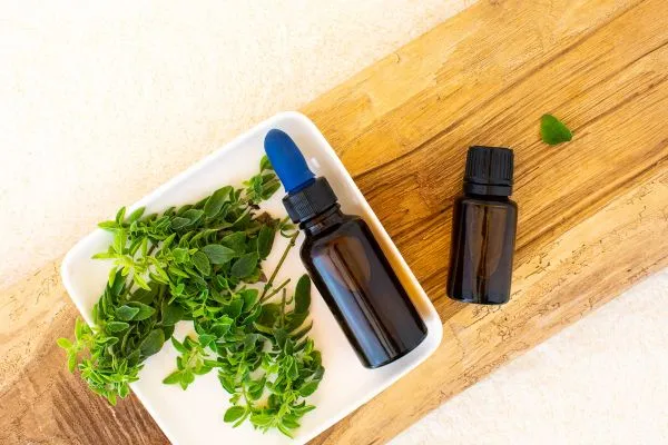 Pipetflesje en druppelfles oregano oil en planten