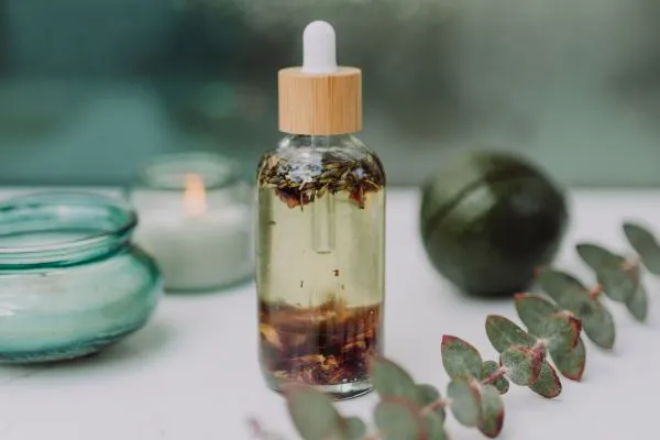 Eucalyptus olie in een potje met brandende kaarsen in het groen