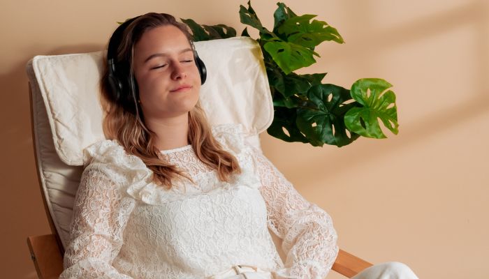 Koptelefoon op hoofd van een vrouw op een stoel
