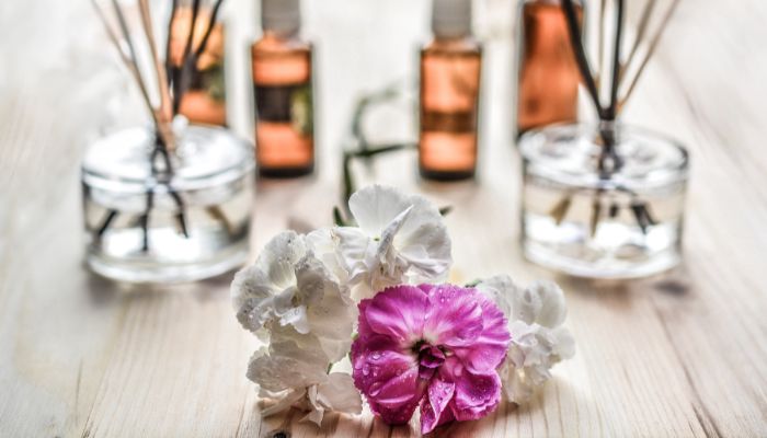 Roze en witte bloemen met geurstokjes en olien op de achtergrond